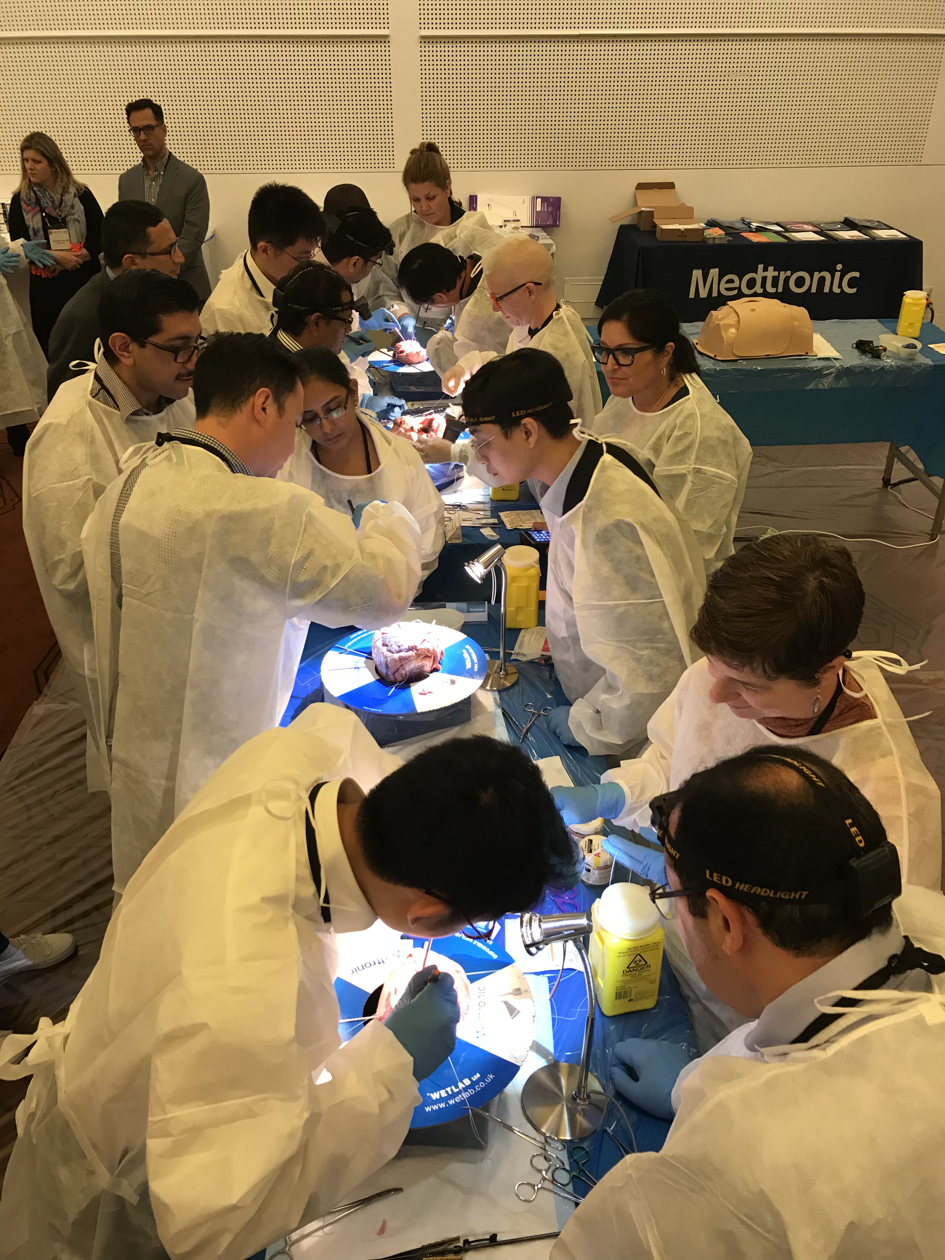 Several individuals in white coats collaborating around a table.